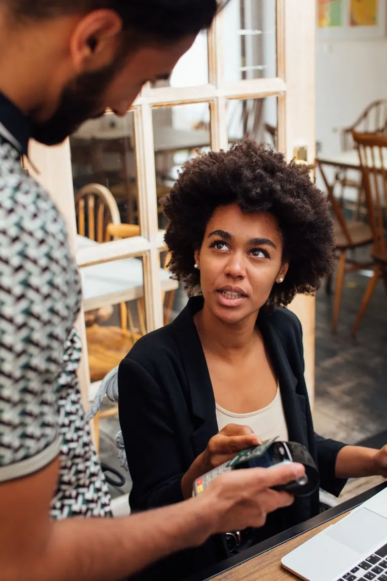 Femme utilisant son smartphone pour effectuer un paiement ou consulter un rappel de facture.