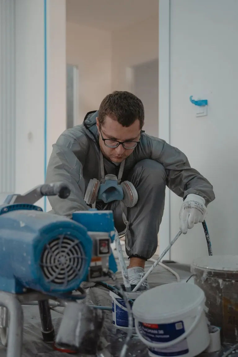 Quickote vs Pennylane — homme peignant à l'intérieur pour un projet de rénovation de maison avec un équipement de professionnel