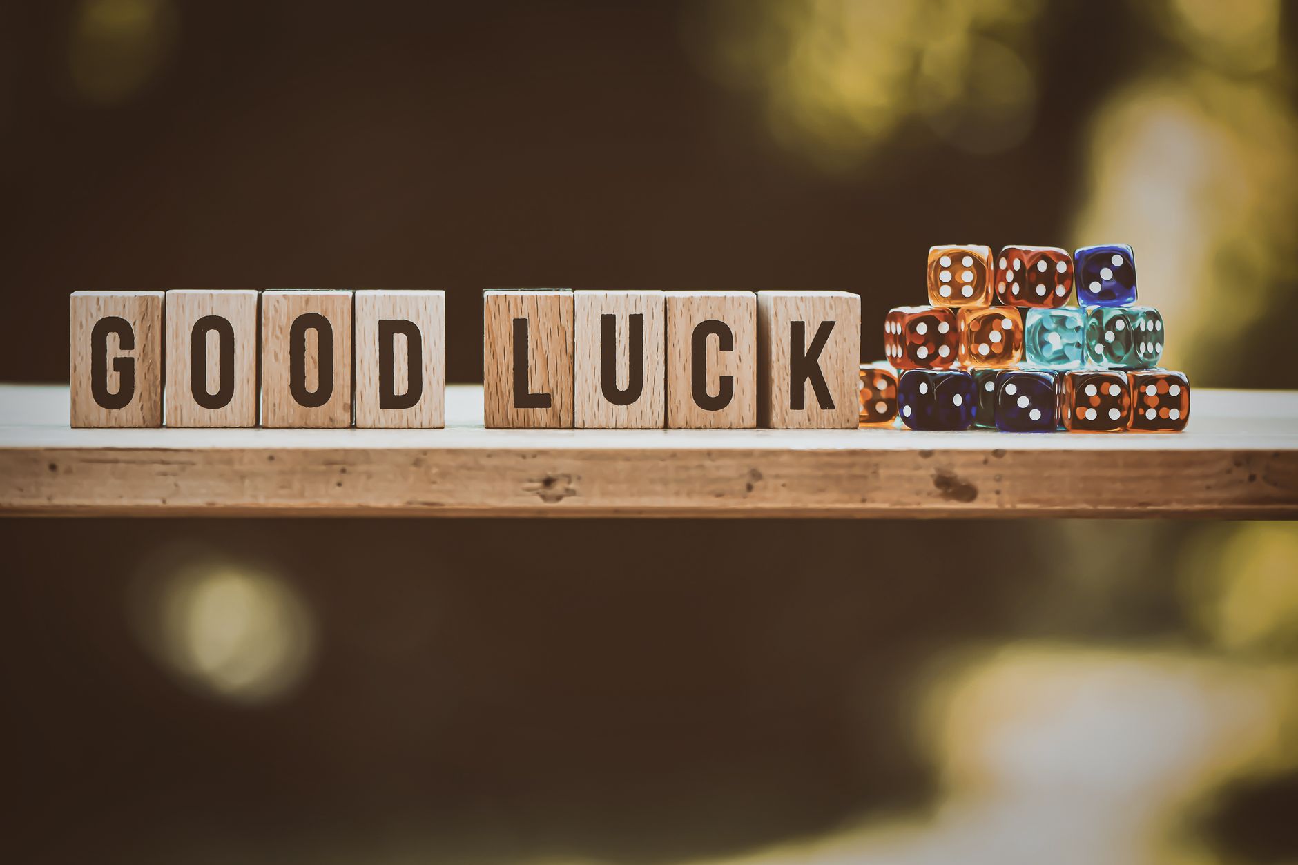 Dés colorés et lettres en bois évoquant le jeu appliqué à la gestion.
