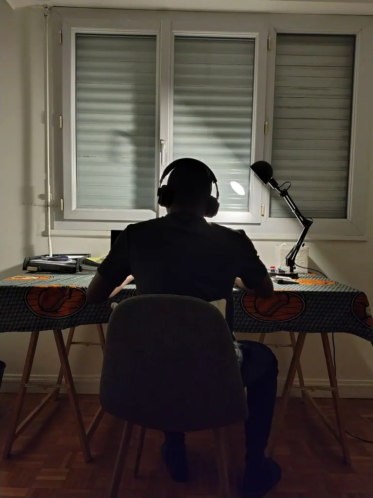 Quickote VS Tiime — silhouette d'un indépendant travaillant tard à son bureau avec un casque audio