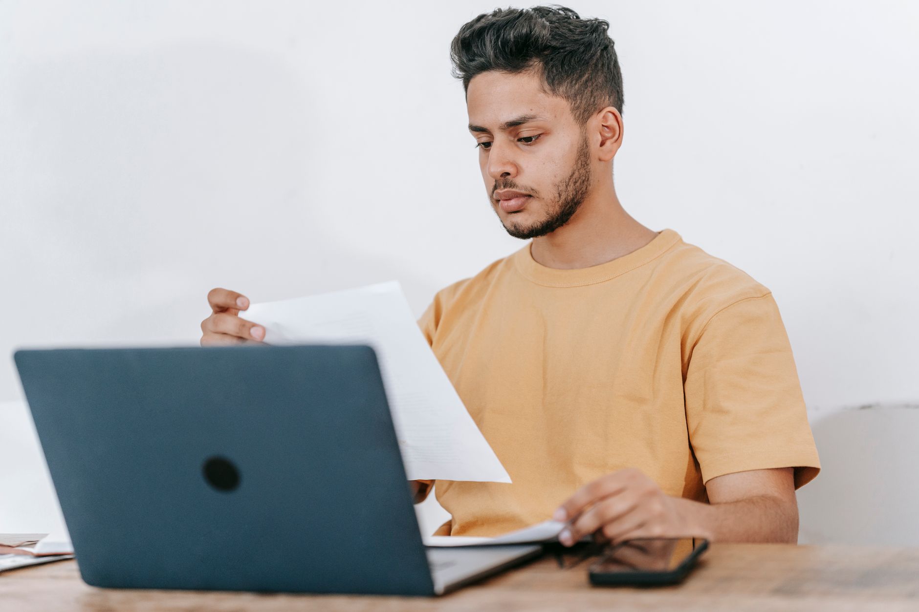 Indépendant comparant des documents administratifs devant son ordinateur