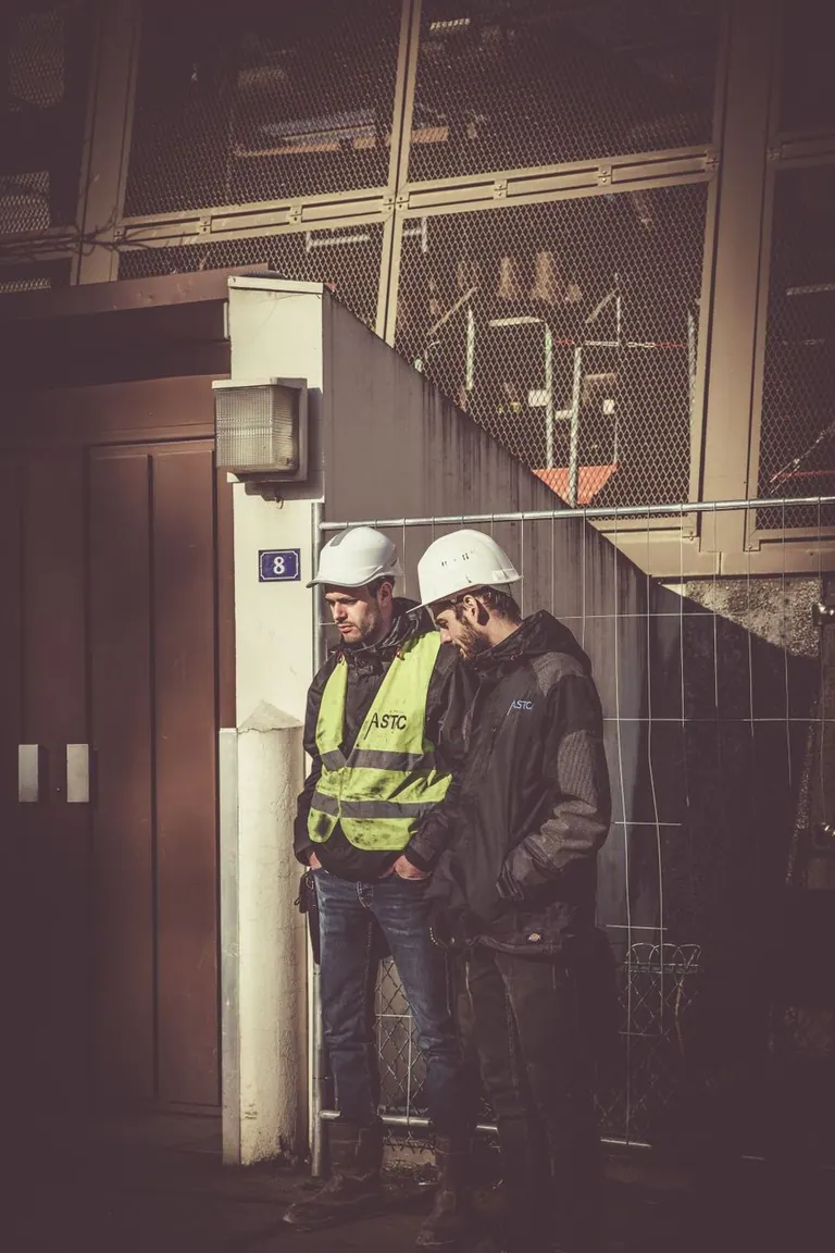 Dos obreros de la construcción conversando en una obra