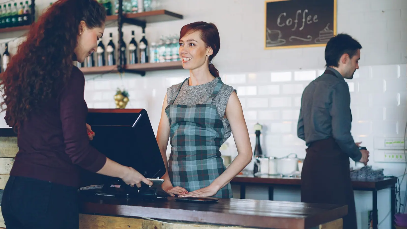 Barista interagissant avec un client au comptoir, symbole de la relation commerciale au quotidien.