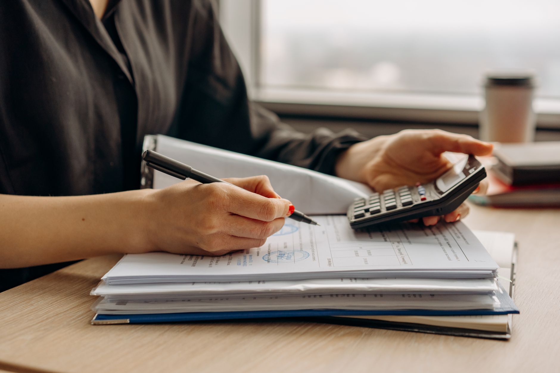 Quickote vs Henrri — indépendant vérifiant ses montants à la calculatrice avec ses documents